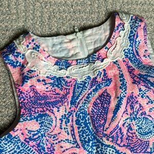 Classic sleeveless shift dress with hem bows, and pockets.